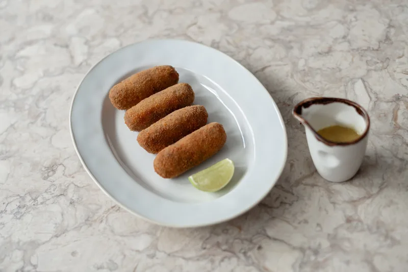 Croquetes do MENOSUM feitos com carne da casa e servidos com molho especial