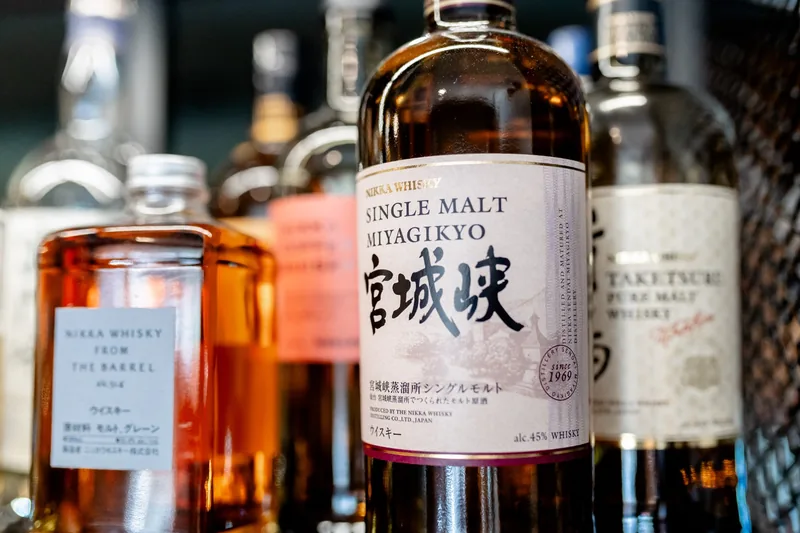 Garrafa de whisky japonês em destaque na garrafeira do MENOSUM