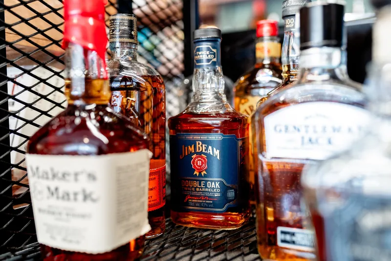 Seleção de bourbons e whiskies americanos na garrafeira do MENOSUM